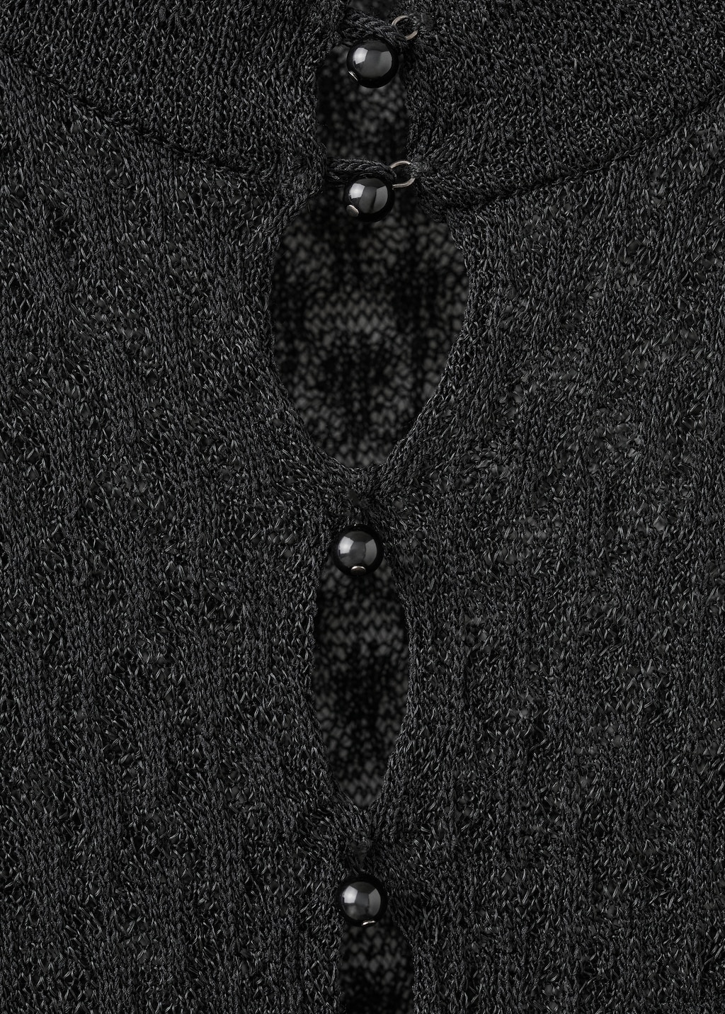 Openwork knitted sweater with bead fastening