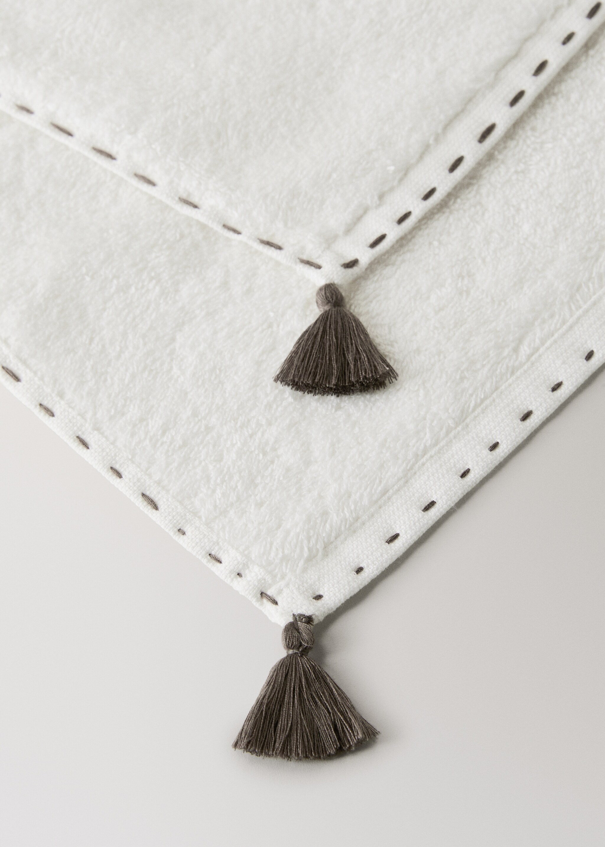 Hand towel with topstitch finish and pompom detail - Details of the article 2, Off White. Ref: 27001568-00.