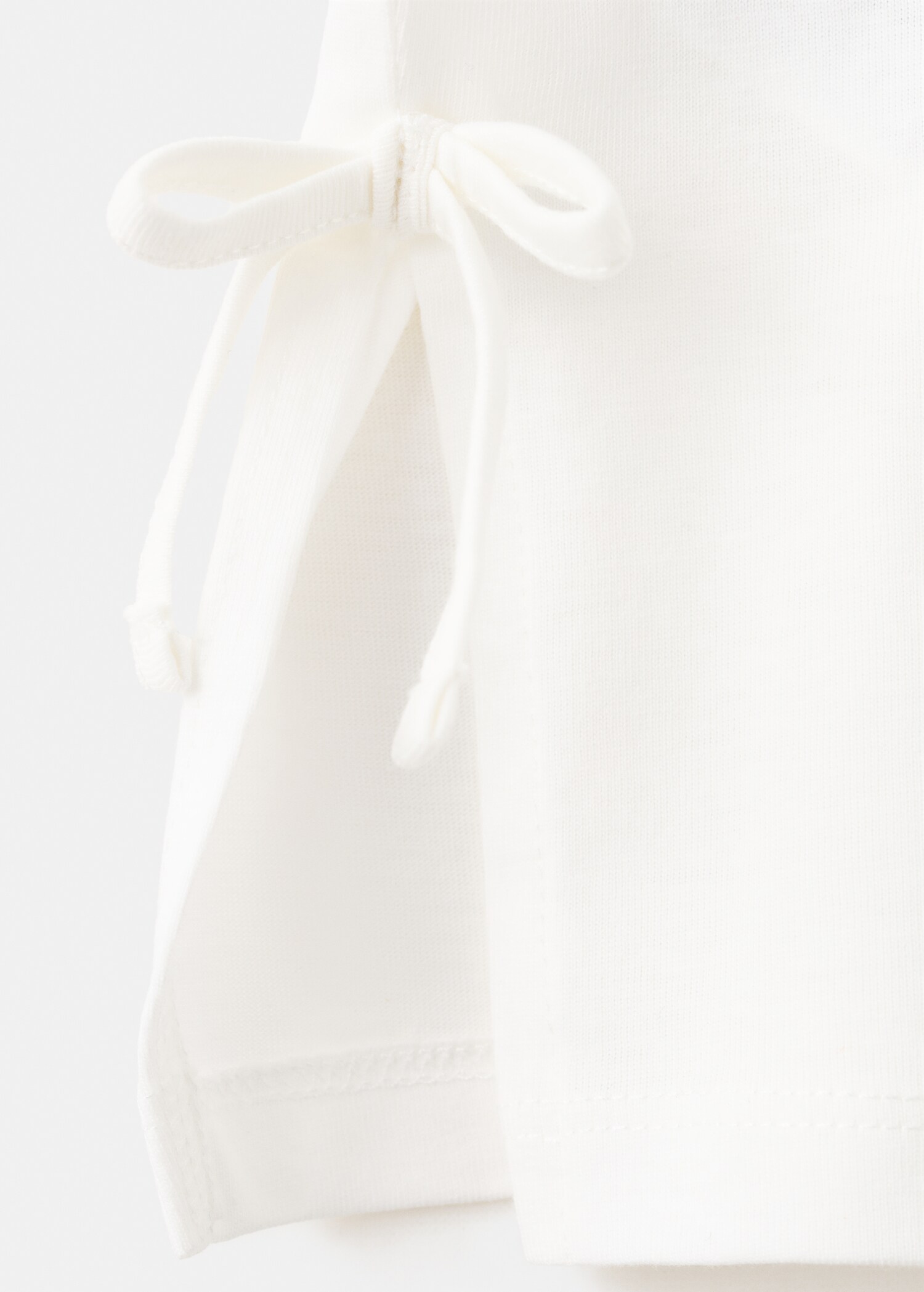 Футболка з принтом та декоративними бантиками - Детальніше про товар 0