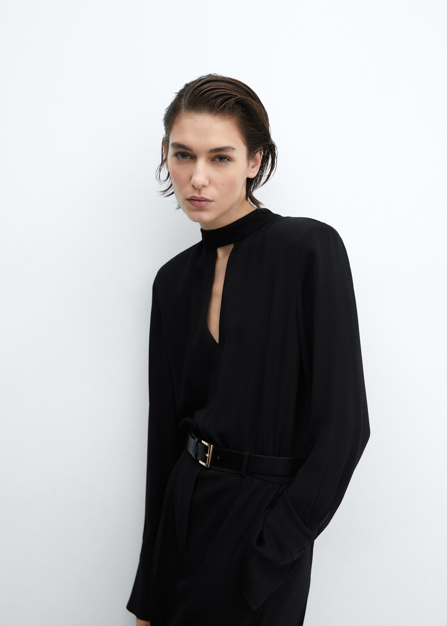 The straight leg of the high-waisted jumpsuit includes the belt