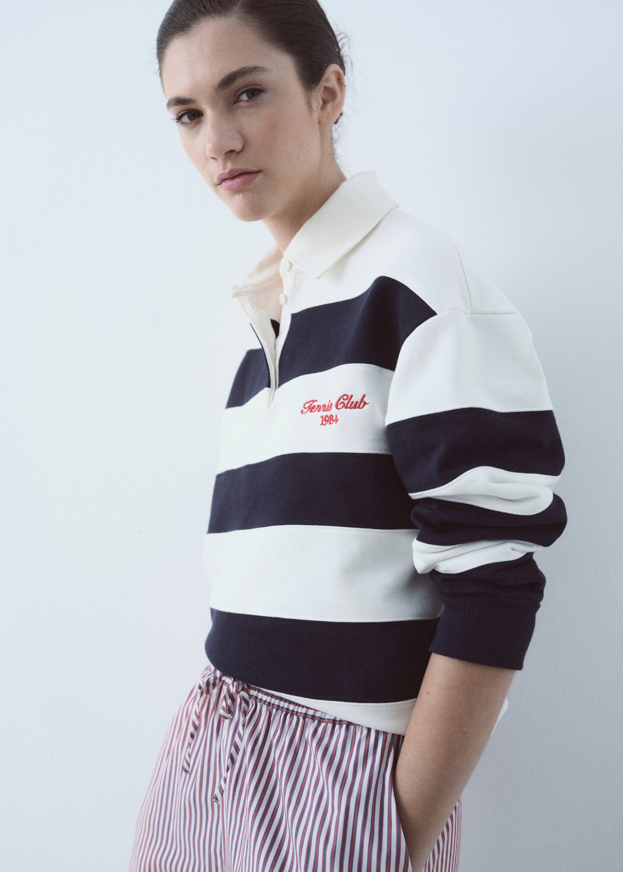 Gestreiftes Poloshirt mit aufgesticktem Schriftzug - Mittlere Ansicht