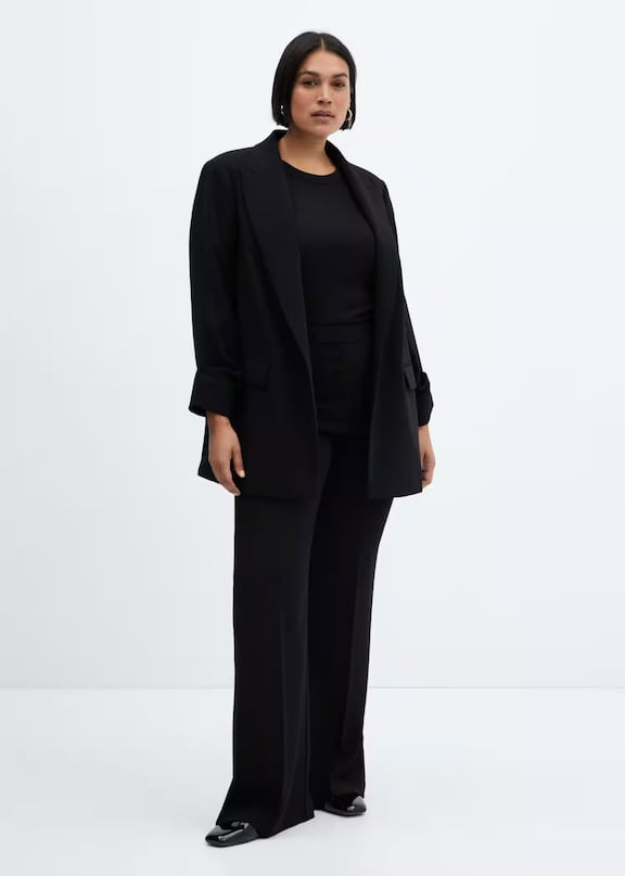 Mujer llevando un traje de chaqueta negro de estilo minimalista