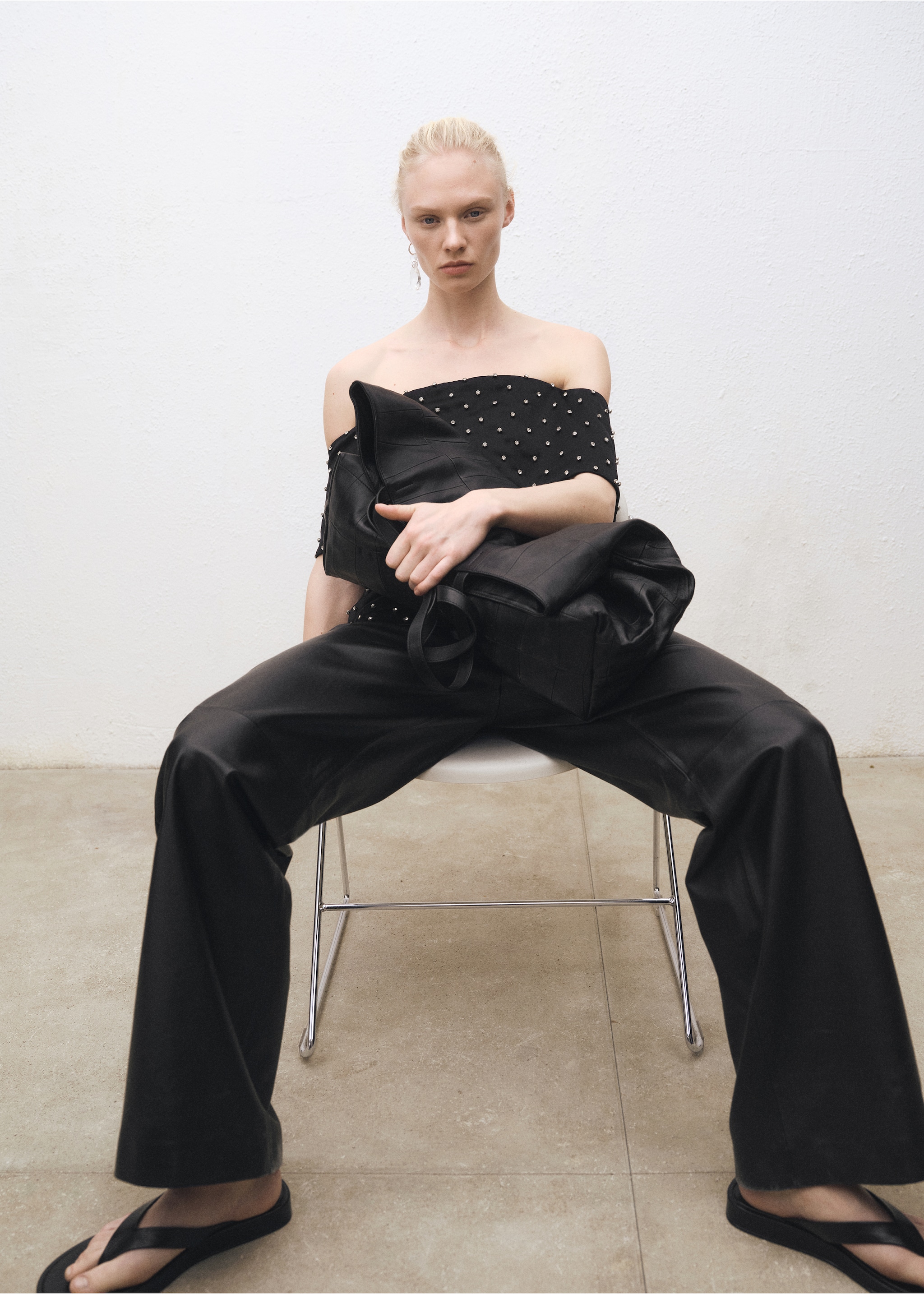 Woman wearing a look with leather trousers and a white shirt