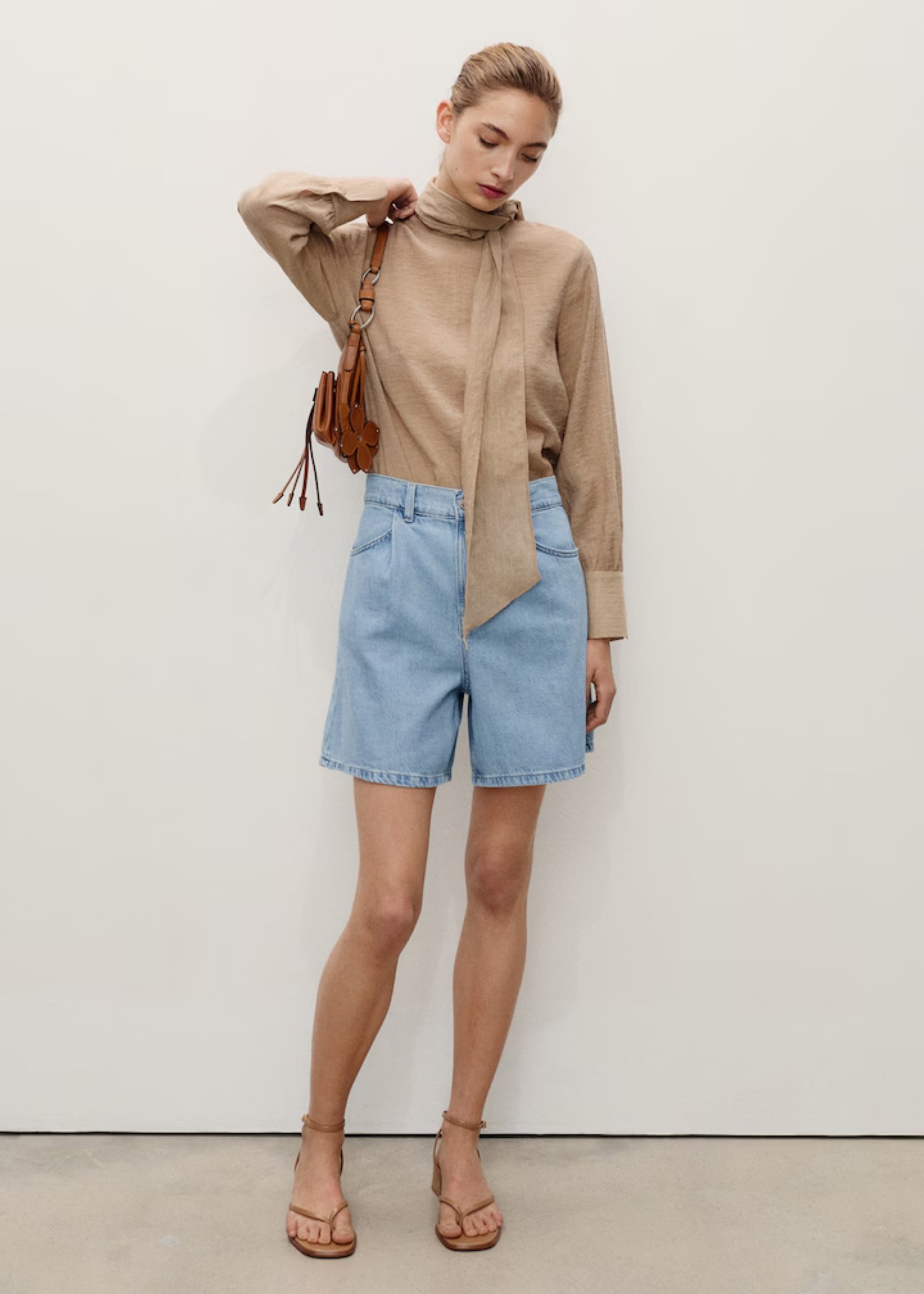 Woman wearing a look with Bermuda shorts and striped top.