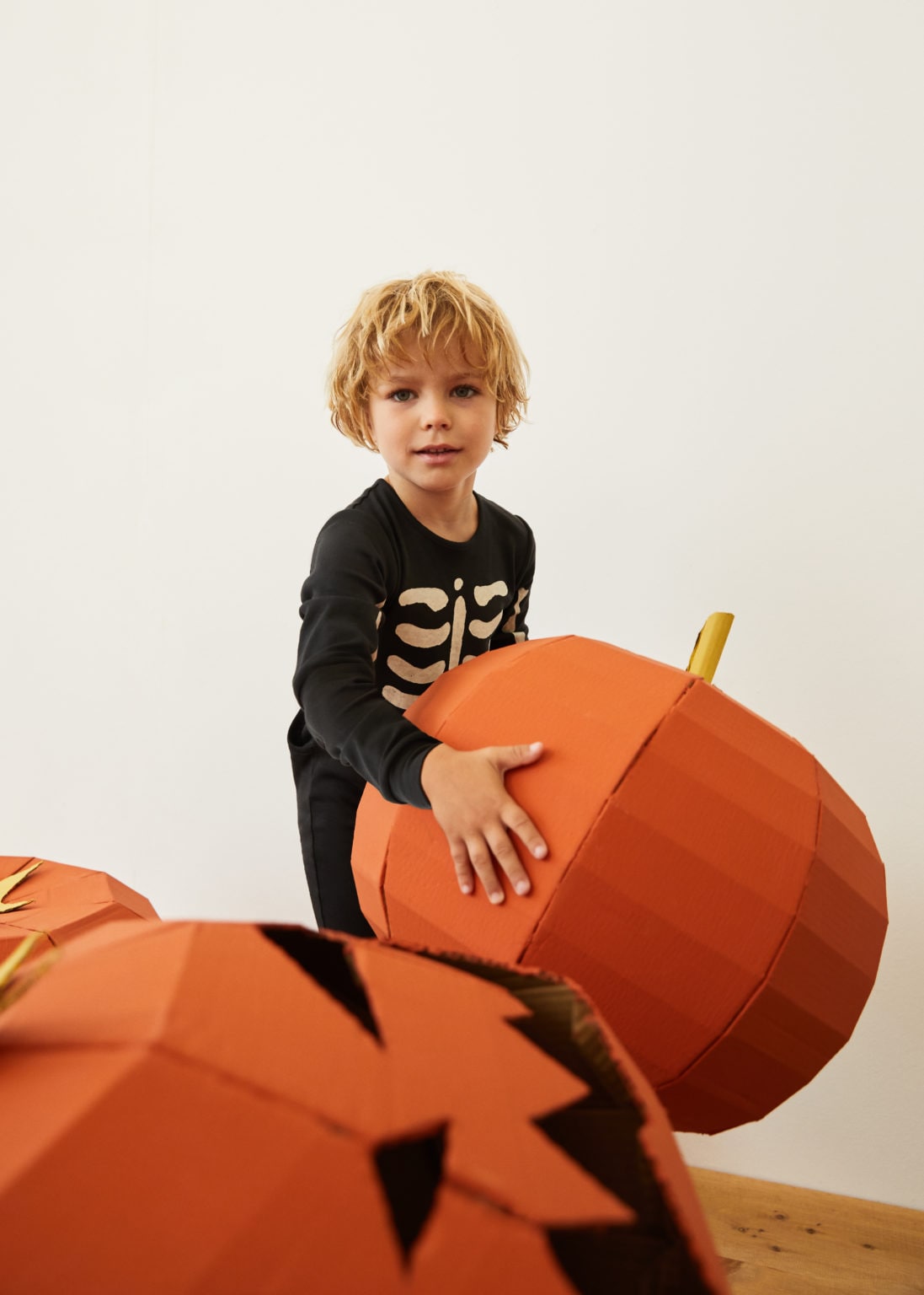 Niño disfrazado jugando con calabazas