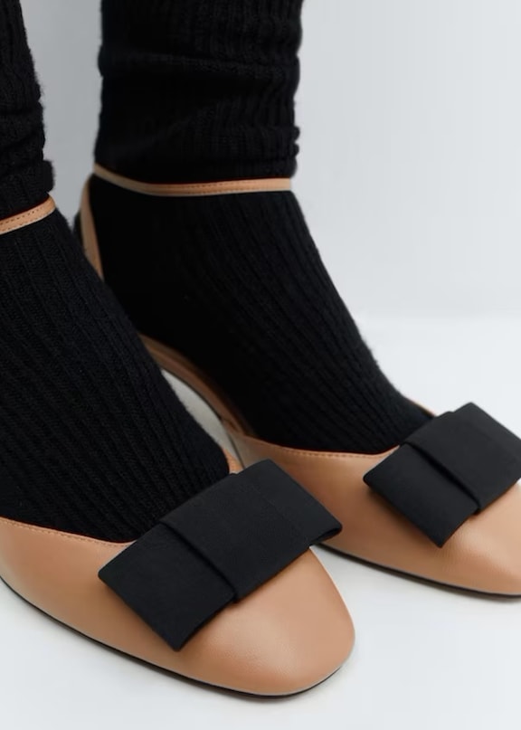 Zapatos estilo coquette bailarina marrones con un lazo negro.