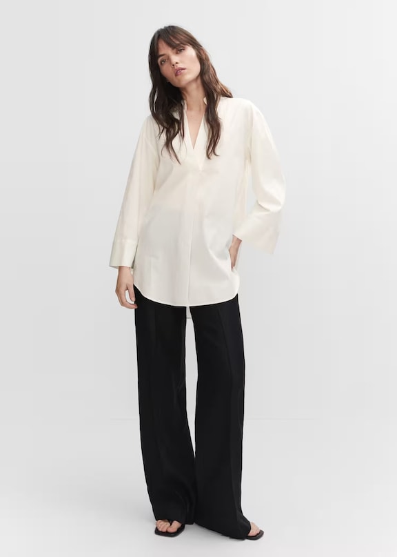 Mujer usando un look oversize con una camisa blanca y un pantalón negro básico