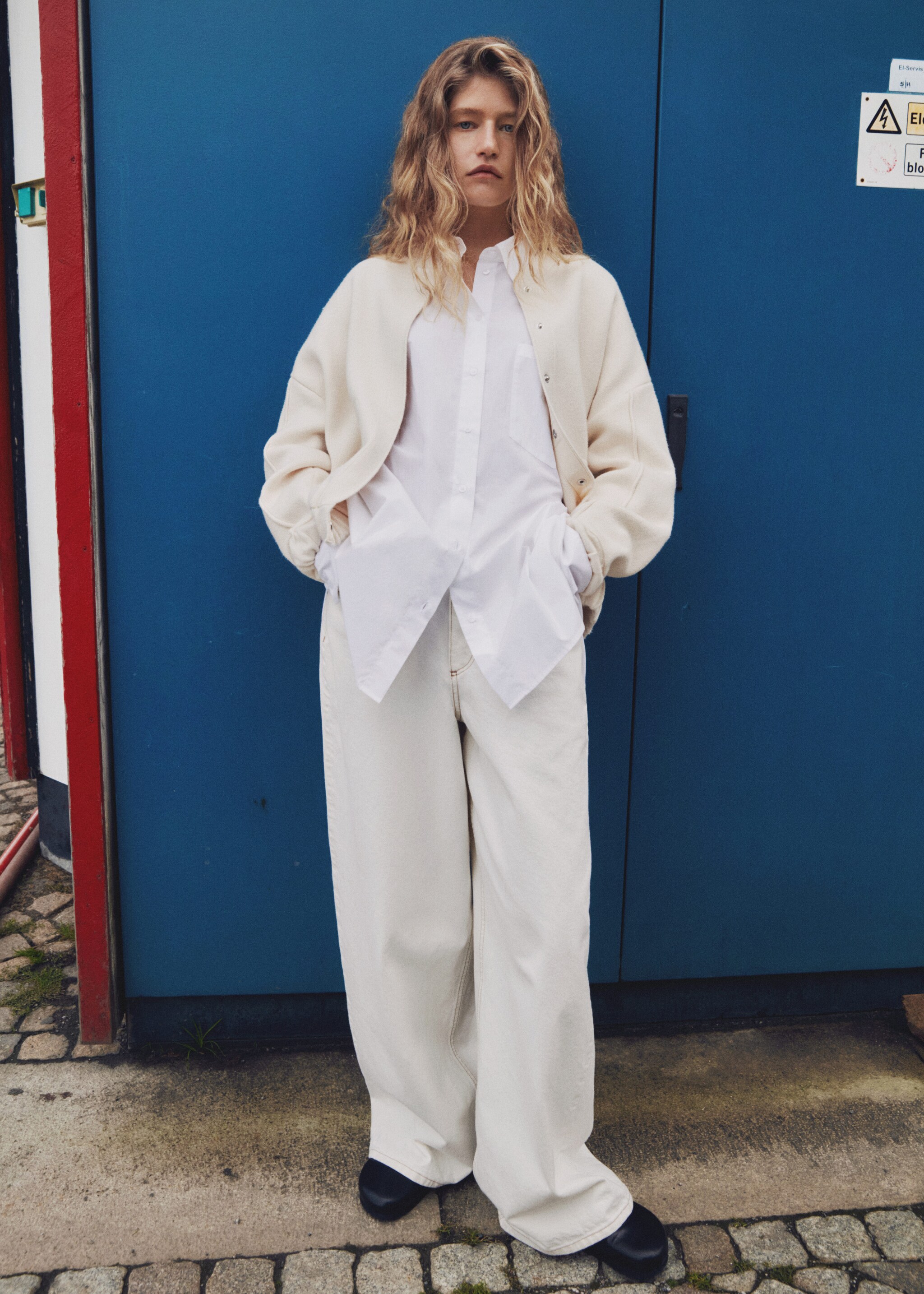 Chica llevando un look de estilo oversize con una camisa y una chaqueta blancas