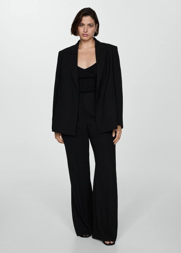 Woman wearing a total black look in a black jacket suit