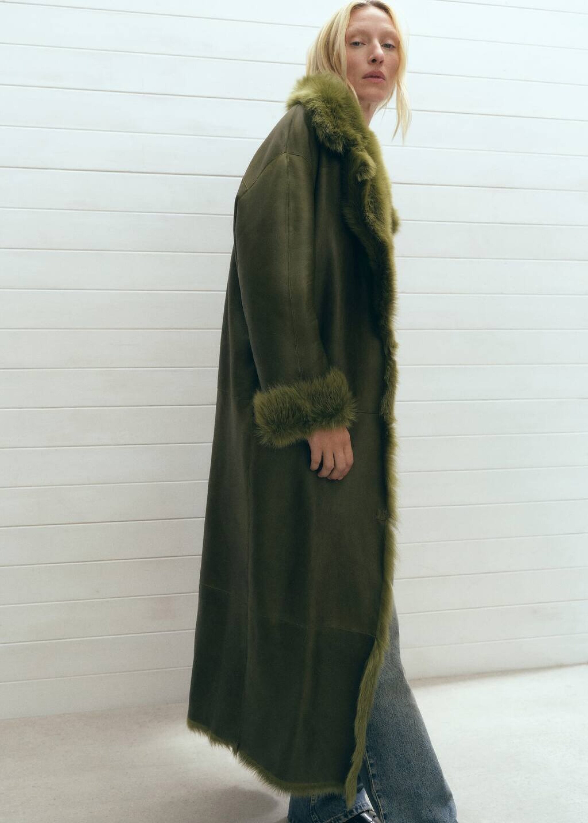 Girl wearing a kind of brown coat with white fur.