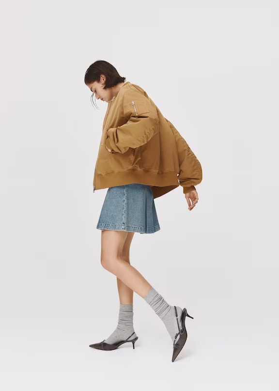 Donna che indossa un look estetico con giacca di jeans e minigonna