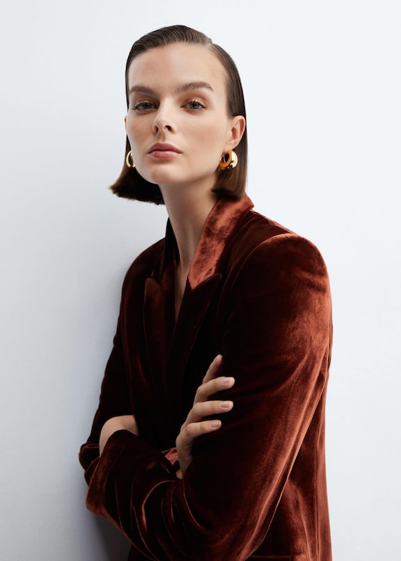 Woman wearing a copper-coloured velvet blazer