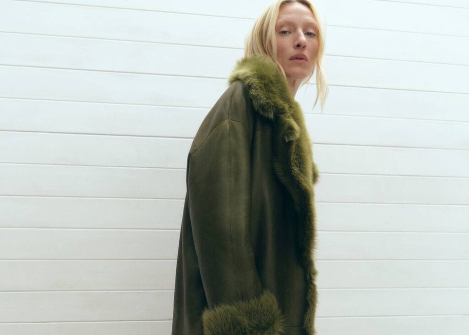 Girl wearing a kind of brown coat with white fur.