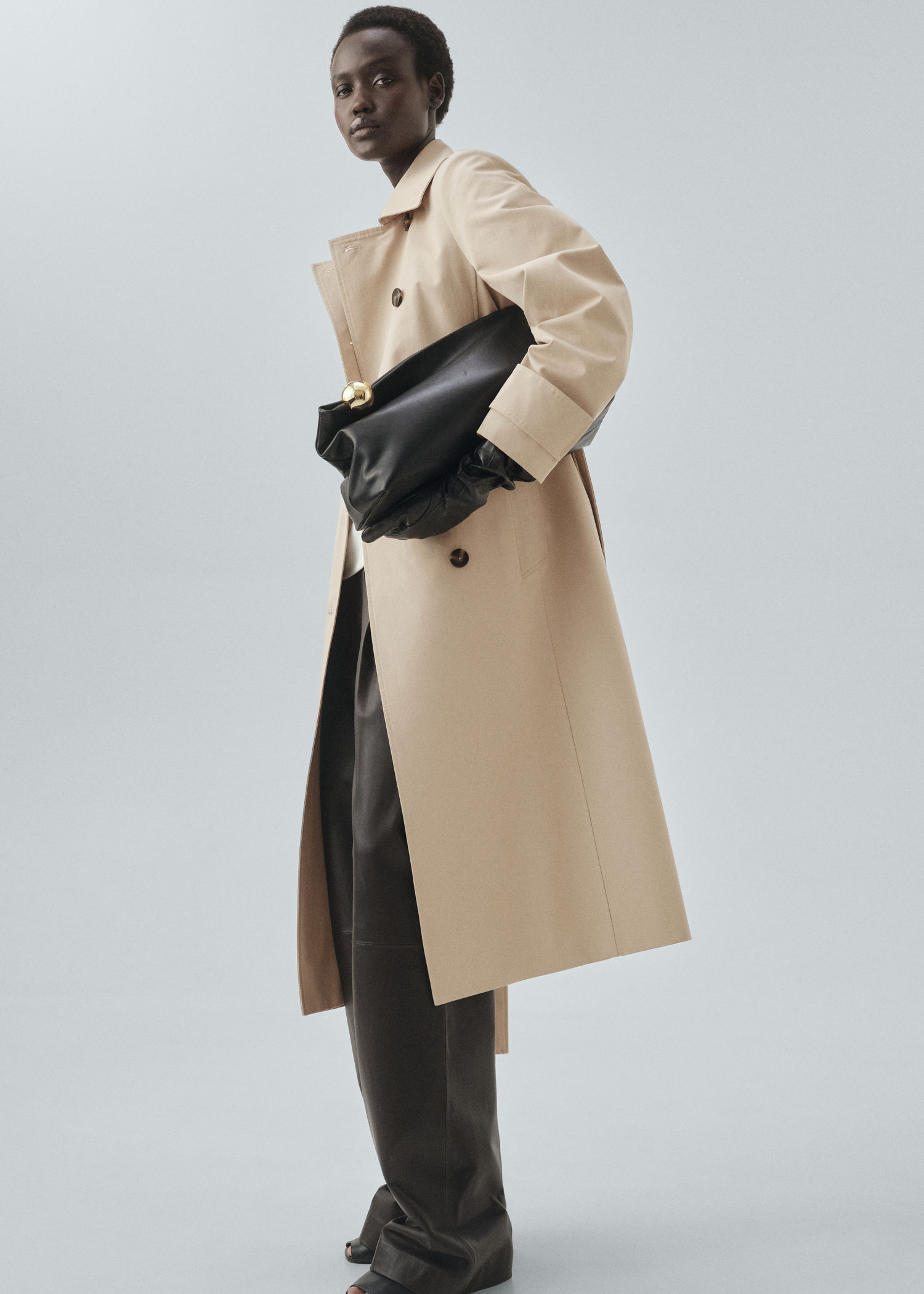 Mujer llevando un look con gabardina color beige