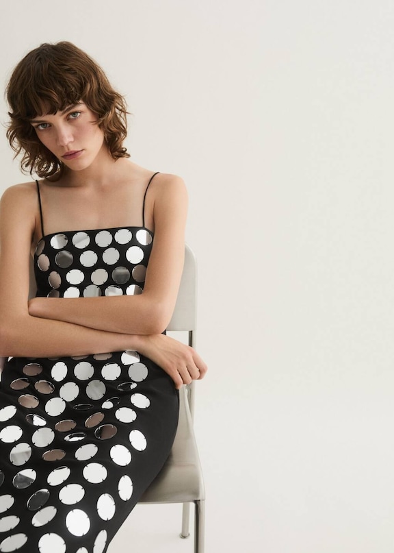 Un look con un vestido negro con espejos.