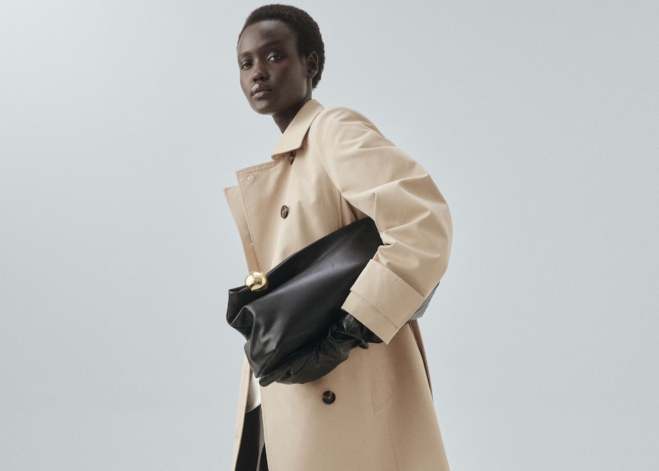 Mujer llevando un look con gabardina color beige