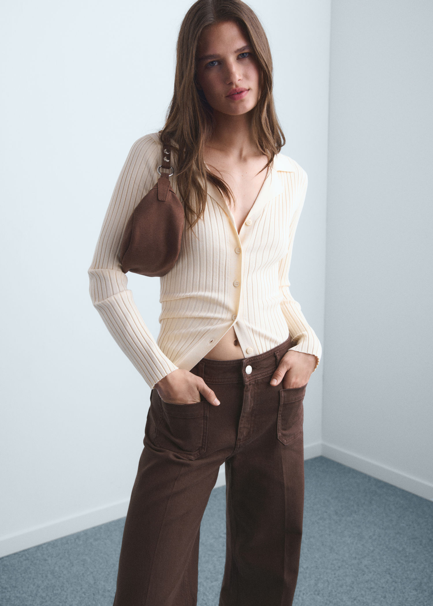 Donna che indossa un abbigliamento casual con gonna e maglione marrone.