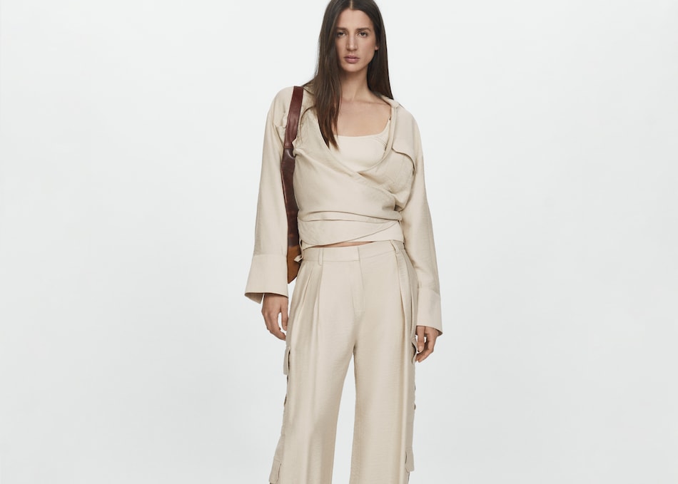 Woman combining beige cargo trousers with an oversize shirt.
