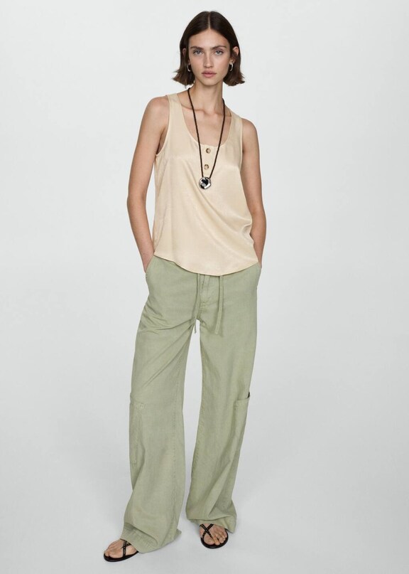 Woman combining beige cargo trousers with a green top.