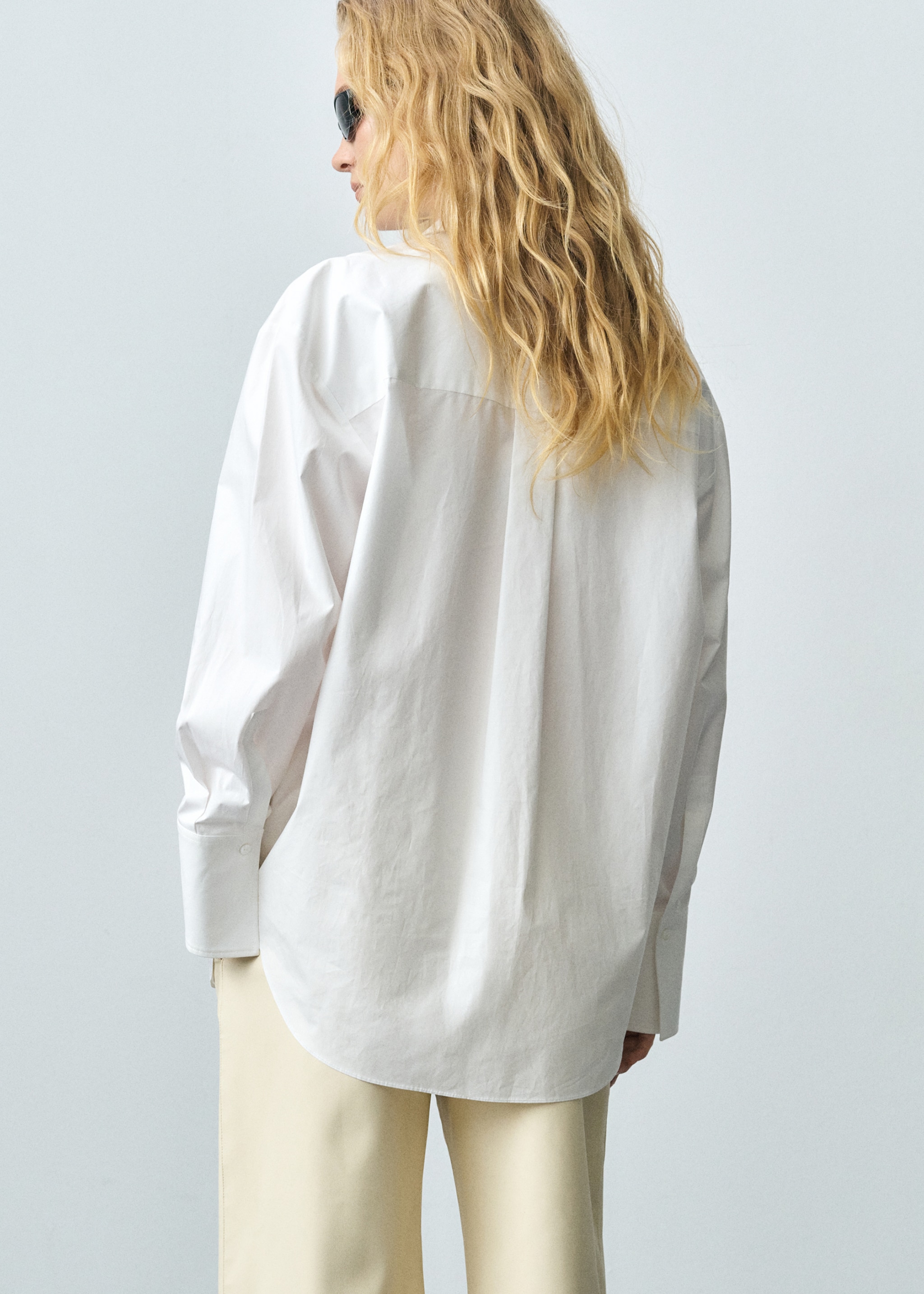 Woman wearing a look with oversize white shirt.