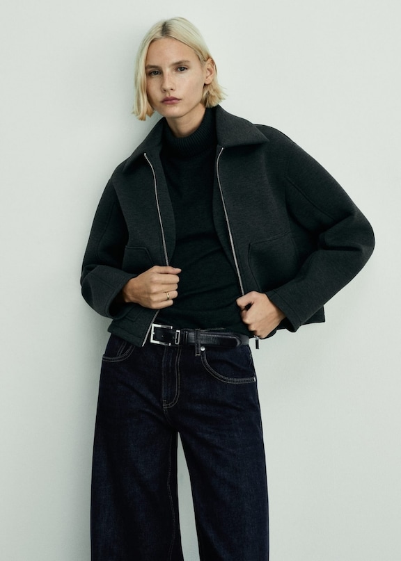 Woman wearing a total black look with an oversized jacket and wide trousers