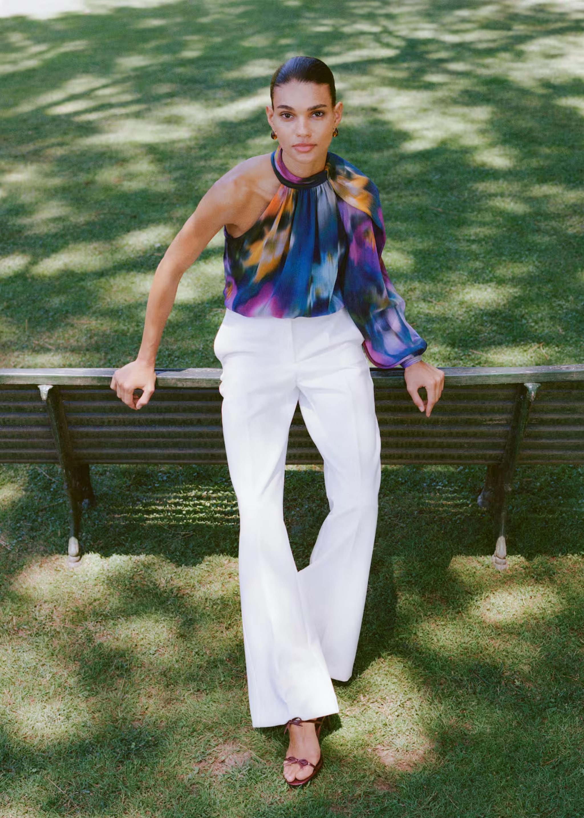 Woman wearing a fur coat and white pants.