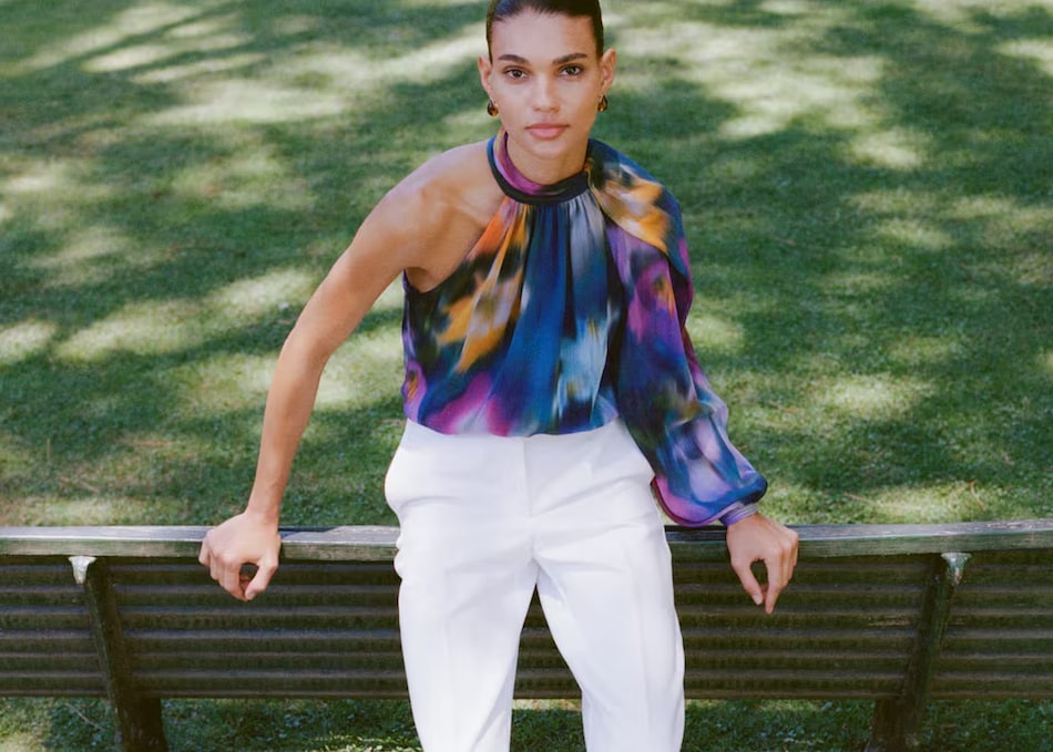Woman wearing a fur coat and white pants.