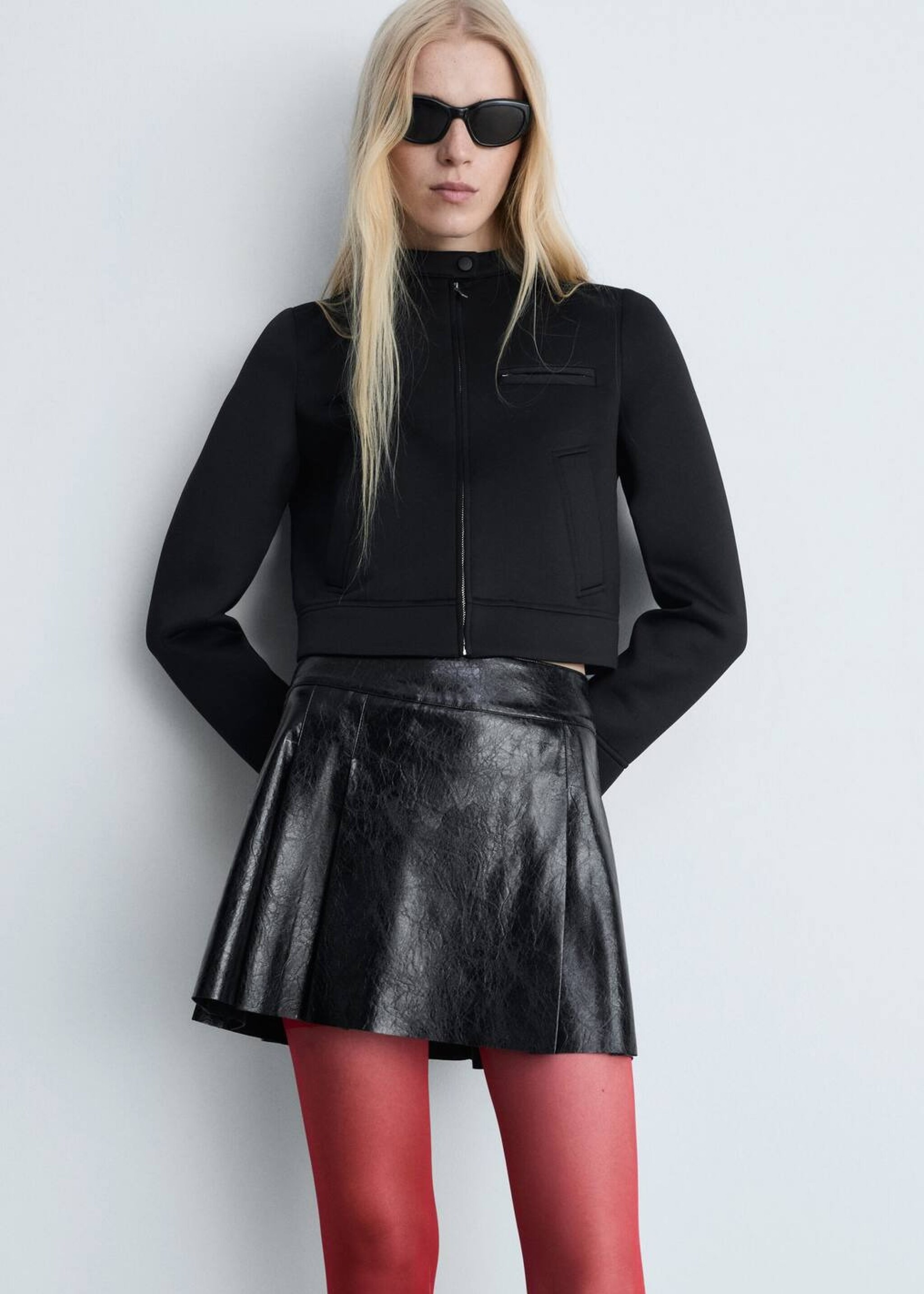 Mujer usando un look de concierto de invierno con un jersey marrón y una falda negra
