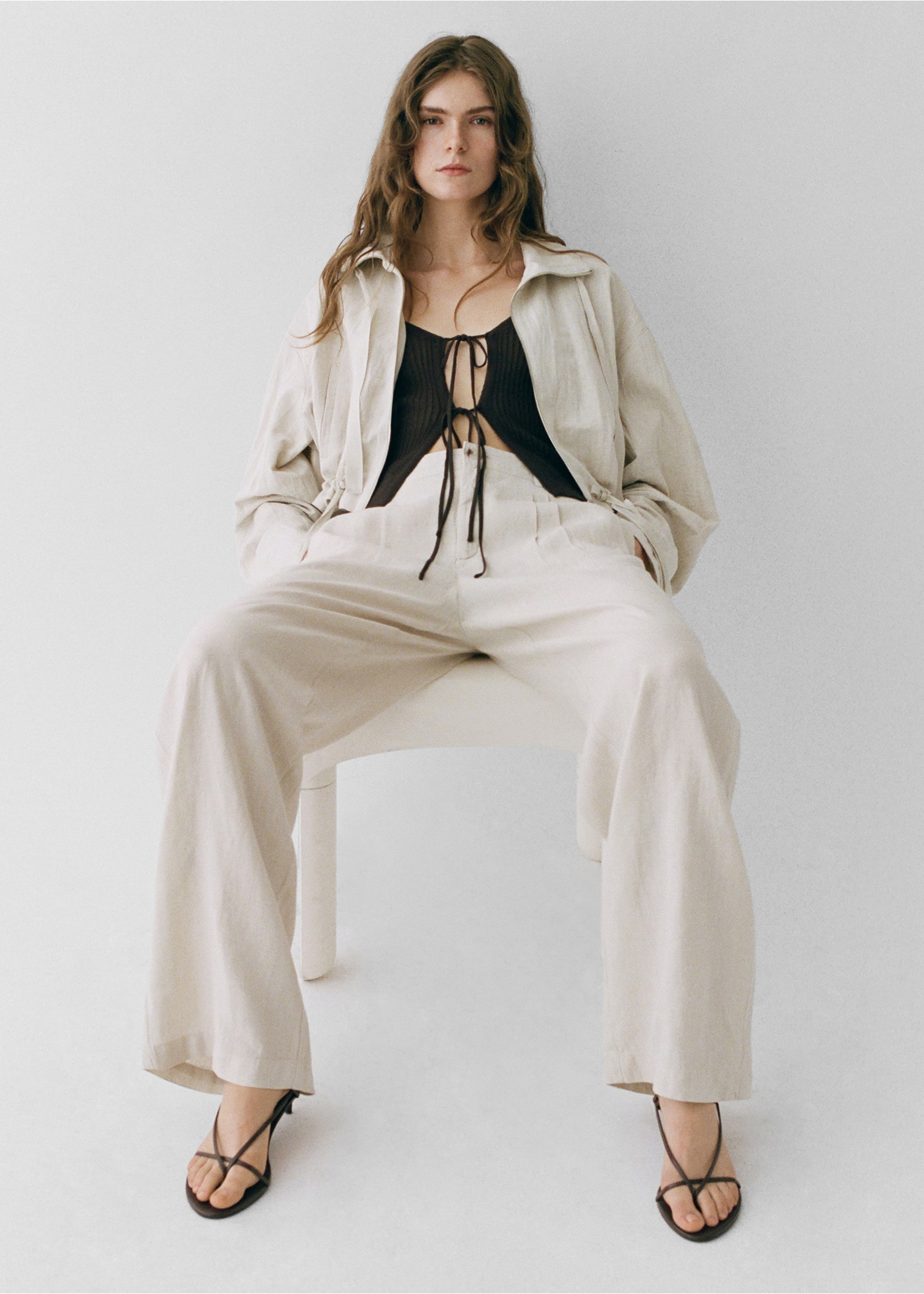 Woman wearing a total look with beige pants