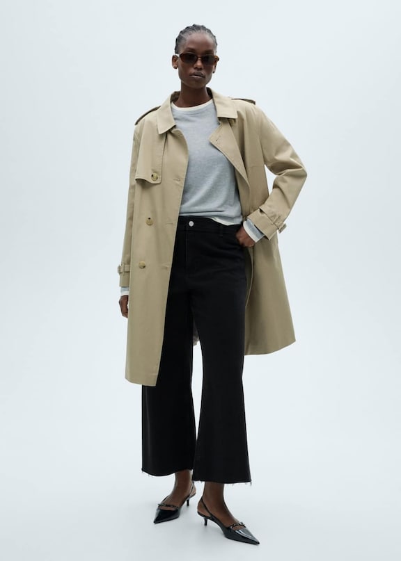 Mujer con un look de gabardina casual.